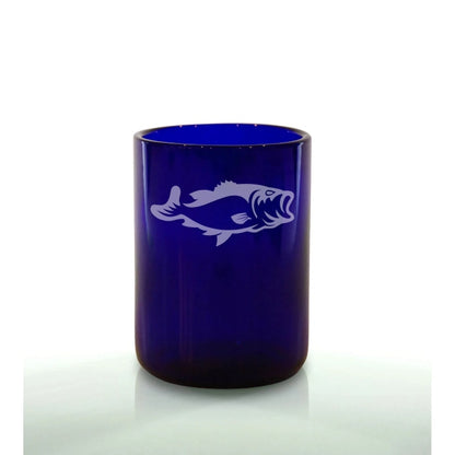 A blue glass with a white engraved design of a fish.